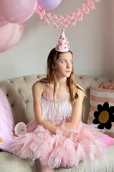 girl wearing a pink tutu dress and party hat