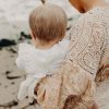 baby in an off white lace romper sunsuit